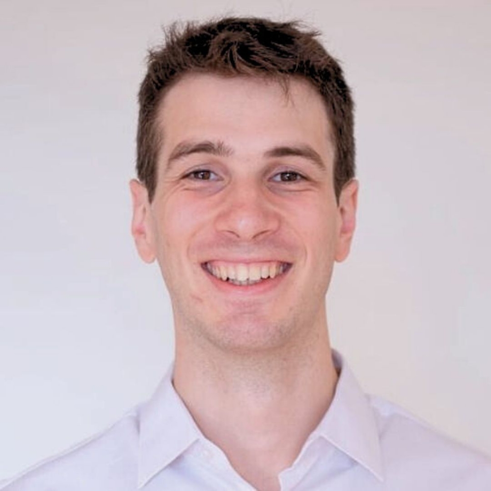 Chris, team member, smiling in a white shirt