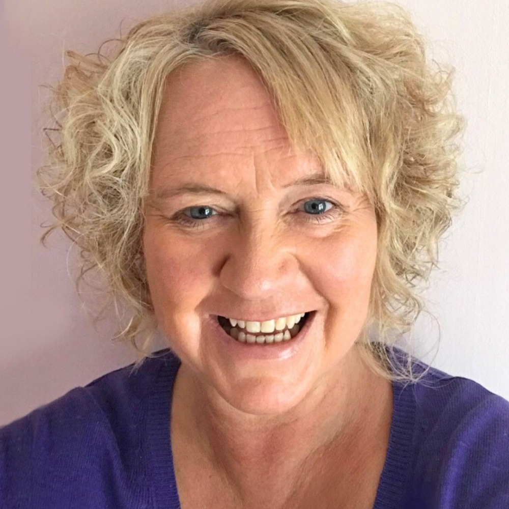 Tracey, team member, smiling in a dark purple shirt